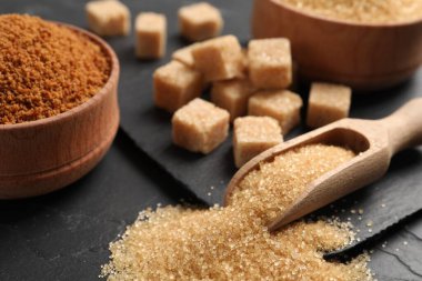 Siyah masada kahverengi şekerli kepçe, yakın plan.