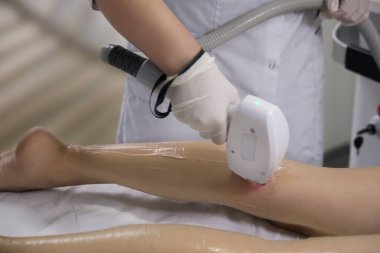 Woman undergoing laser epilation procedure in beauty salon, closeup