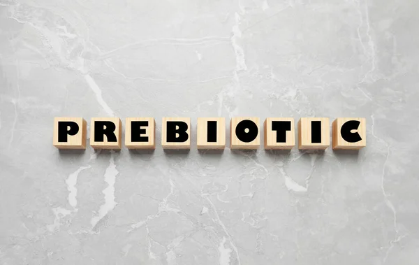 浅灰大理石桌子上有单词Prebiotic的木制立方体 — 图库照片