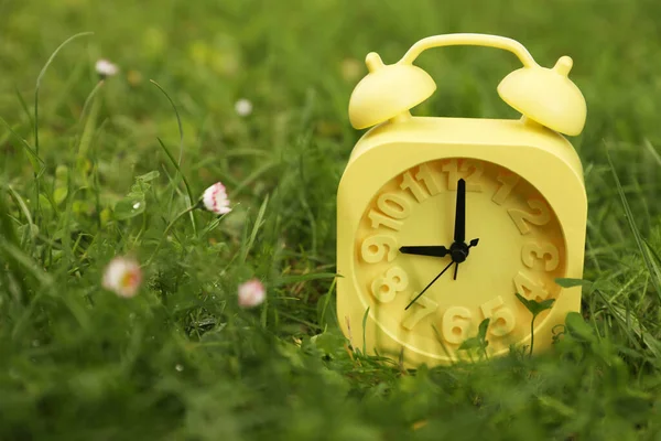 緑の芝生の屋外で黄色の目覚まし時計 クローズアップ — ストック写真