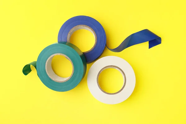 stock image Colorful insulating tapes on yellow background, flat lay