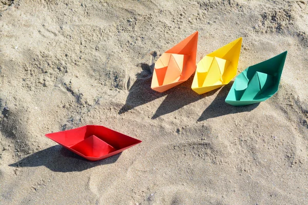Many paper boats on sandy beach, above view