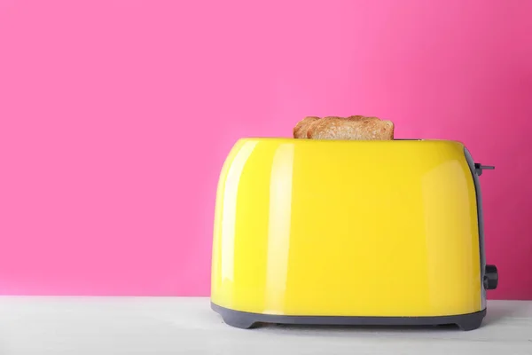 现代烤面包机与切片烤面包在白色木制桌子上 案文的篇幅 — 图库照片