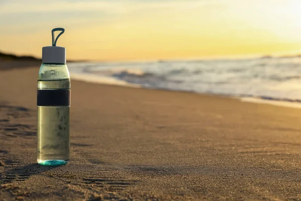 Botella Vidrio Con Agua Sobre Arena Mojada Cerca Del Mar —  Fotos de Stock