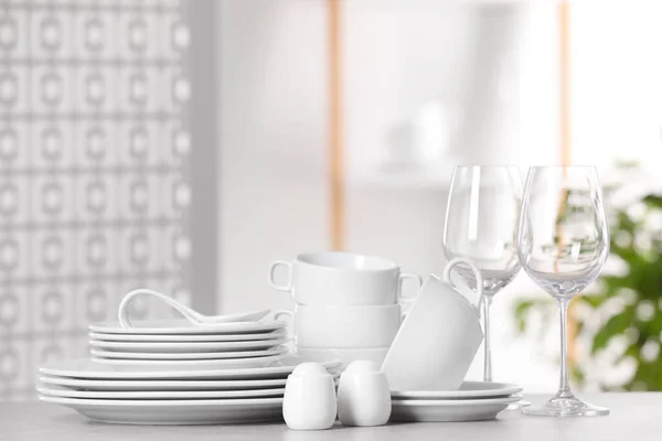 ライトグレーのテーブルの上にきれいな食器と眼鏡のセット テキストのためのスペース — ストック写真
