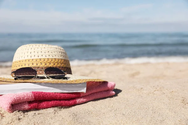 Chapéu Óculos Sol Livro Toalha Listrada Praia Areia Perto Mar — Fotografia de Stock