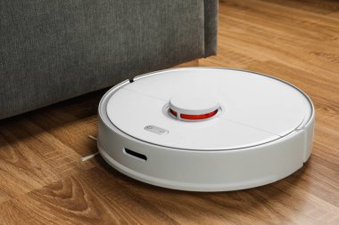 Robotik süpürge, ahşap zeminde, kapalı alanda.