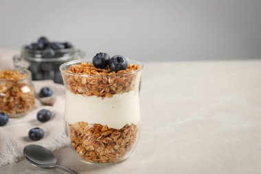 Bir bardak yoğurt, granola ve mermer masada yaban mersini, yakın plan. Metin için boşluk