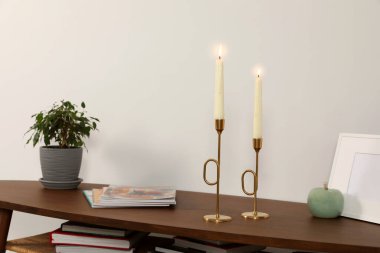 Işık duvarının yanında dekoratif unsurları olan ahşap masa. İç tasarım