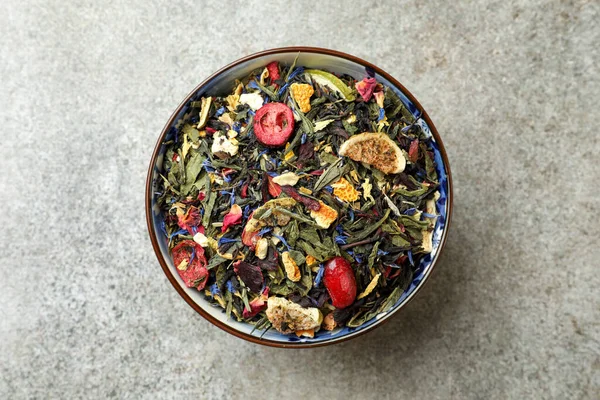 stock image Bowl with dry herbal tea on grey table, top view