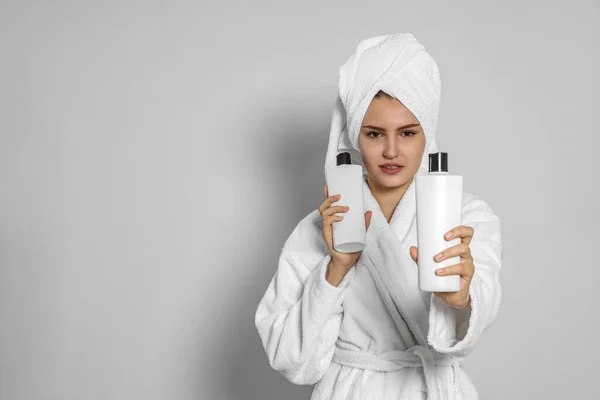 Beautiful Young Woman Bathrobe Holding Bottles Shampoo Light Grey Background — Stock Photo, Image