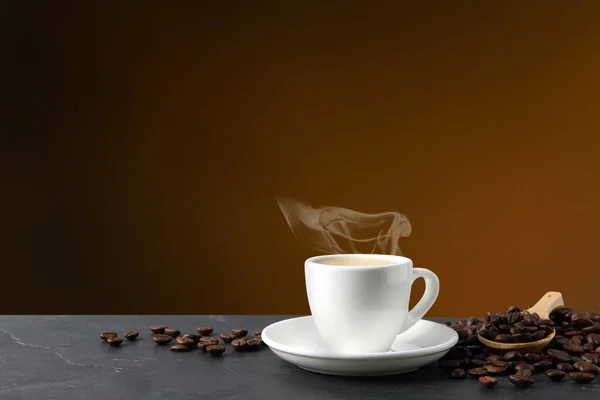 Filiżanka Gorącej Kawy Aromatycznej Palonej Fasoli Czarnym Stole Brązowym Tle — Zdjęcie stockowe