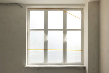 Pencere ve eşik kapalı plastik film ile kaplı.