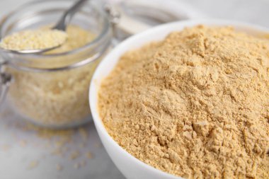 Beyaz masadaki seramik kasede susam unu, yakın plan.