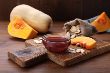 Ahşap masada cam bir kase kabak tohumu yağı.