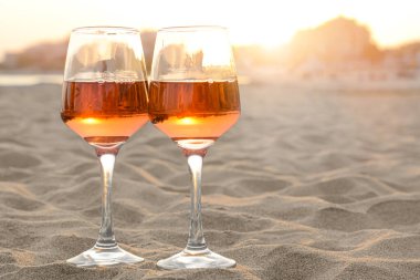 Kumsalda bir bardak lezzetli gül şarabı, mesaj için yer.