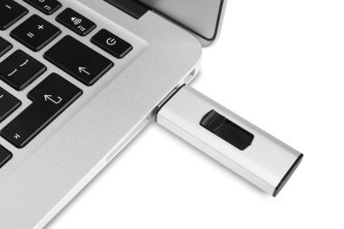 Modern USB flaş bellek beyaz arkaplanda dizüstü bilgisayara bağlandı, yakın plan