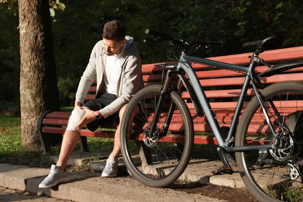 Hombre Con Rodilla Lesionada Banco Cerca Bicicleta Aire Libre — Foto de Stock