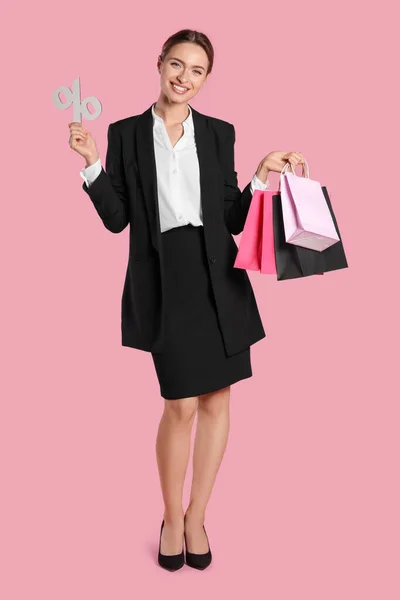 快乐的年轻女子 购物袋和百分比符号在浅粉色背景 大甩卖 — 图库照片