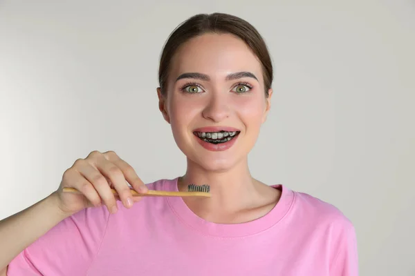Mulher Jovem Escovando Dentes Com Pasta Carvão Vegetal Fundo Claro — Fotografia de Stock