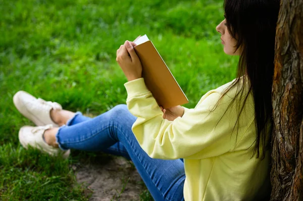 Parktaki Ağacın Yanında Kitap Okuyan Genç Bir Kadın — Stok fotoğraf