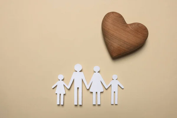 Kağıt Aile Figürleri Bej Arka Planda Ahşap Bir Kalp Sigorta — Stok fotoğraf