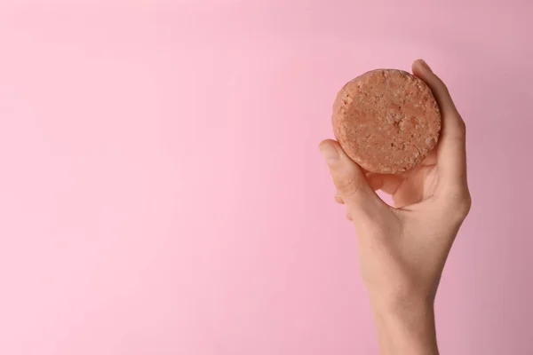 stock image Woman holding solid shampoo bar against pink background, closeup. Space for text