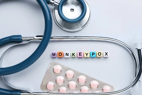 Word Monkeypox Valmistettu Värikkäitä Muovihelmiä Pillereitä Stetoskooppi Kevyellä Taustalla Tasainen — kuvapankkivalokuva