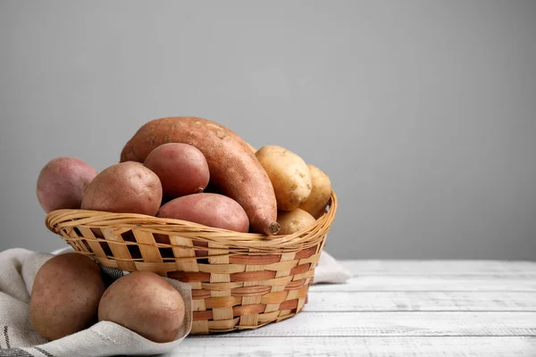 Different Types Fresh Potatoes Wicker Basket White Wooden Table Space — Stock Photo, Image