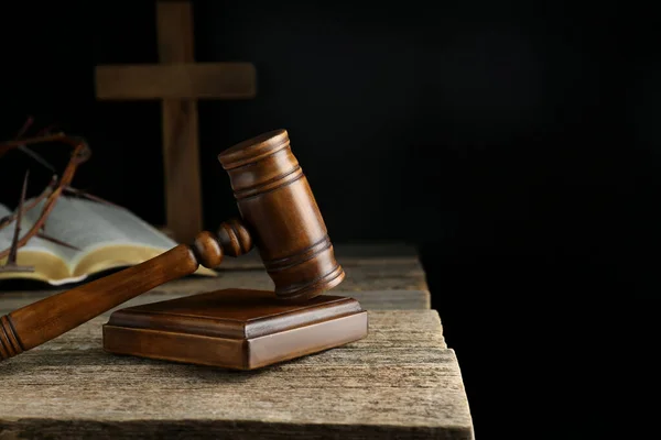 stock image Judge gavel, bible, cross and crown of thorns on wooden table against black background. Space for text