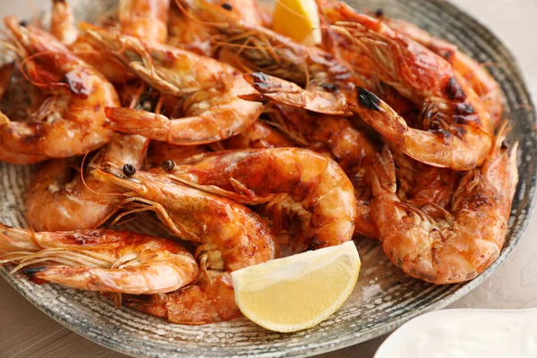 stock image Delicious cooked shrimps served with lemon on plate, closeup