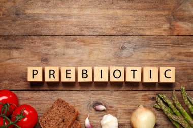 Tahta masa üzerinde harf ve yiyecek içeren küpler içeren prebiyotik kelime. Metin için boşluk