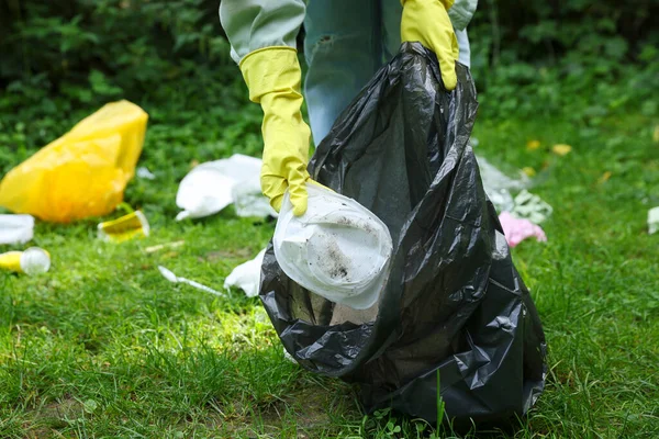 緑の芝生の屋外でゴミを収集ビニール袋を持つ女性 クローズアップ — ストック写真