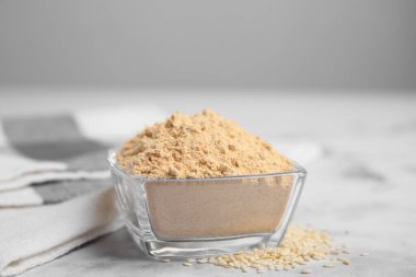 Beyaz mermer masada cam kasede susam unu.