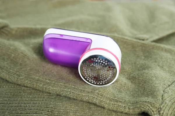 stock image Modern fabric shaver on olive cloth indoors, closeup