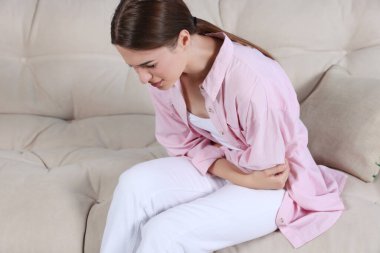 Evdeki kanepede sistit hastası genç bir kadın.