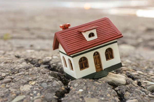 stock image House model in cracked asphalt. Earthquake disaster