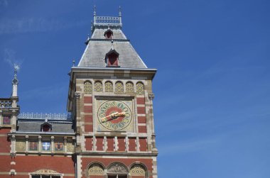 Mavi gökyüzüne karşı saati olan, alçak açılı manzaralı merkezi tren istasyonunun güzel binası. Metin için boşluk