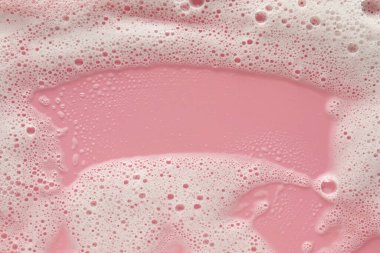 Soluk pembe arka planda beyaz yıkama köpüğü, üst manzara