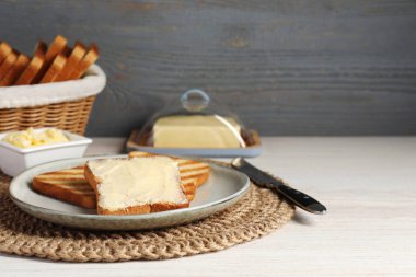 Beyaz ahşap masada tereyağlı lezzetli tostlar servis edilir. Metin için boşluk