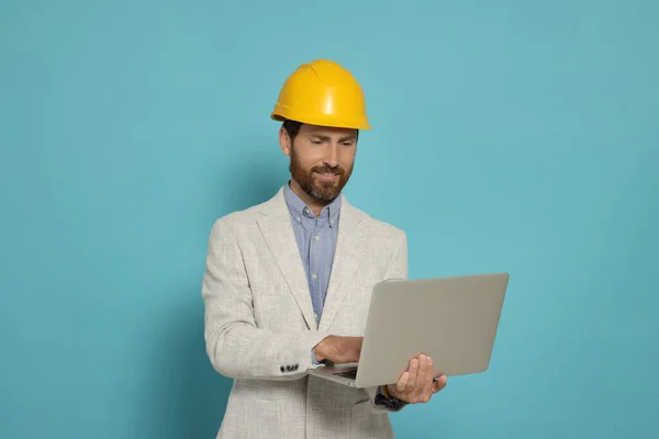 Professioneller Ingenieur Mit Hut Und Laptop Auf Hellblauem Hintergrund — Stockfoto