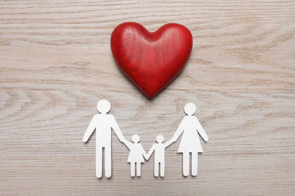 Paper family cutout and red heart on white wooden background, flat lay. Insurance concept