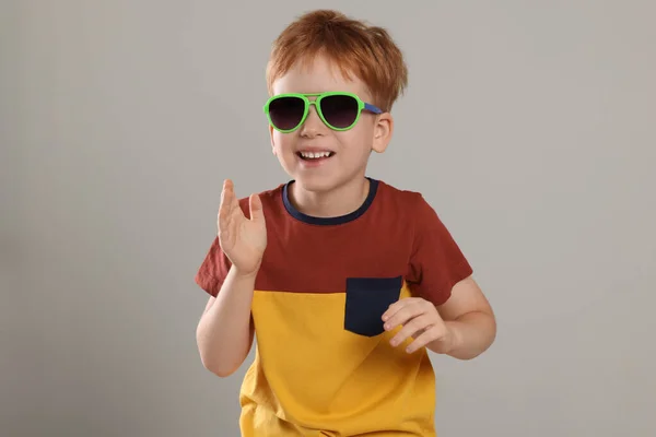 可爱的小男孩 戴着浅灰色背景的太阳镜 — 图库照片