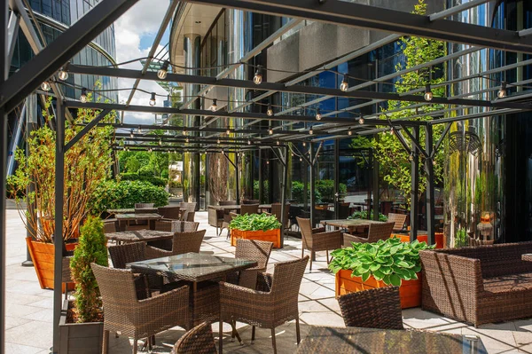 Beautiful cafe with stylish furniture and plants outdoors