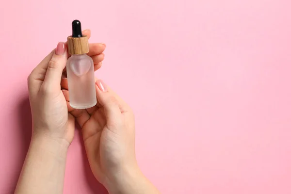 Vrouw Met Fles Met Serum Roze Achtergrond Bovenaanzicht Ruimte Voor — Stockfoto