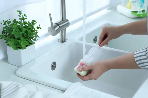 台所で哺乳瓶を洗う女性 クローズアップ — ストック写真