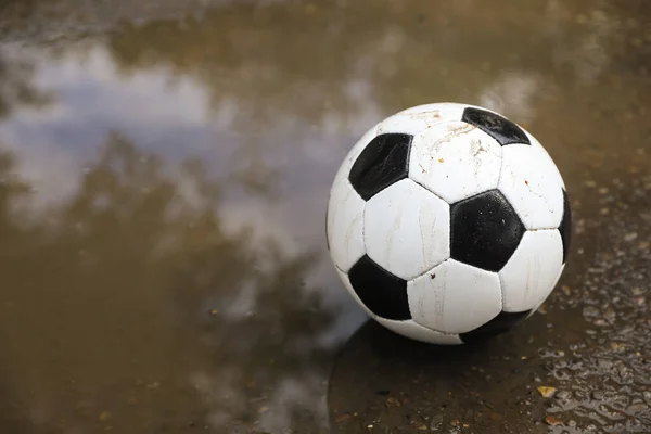 stock image Soccer ball near puddle outdoors, space for text