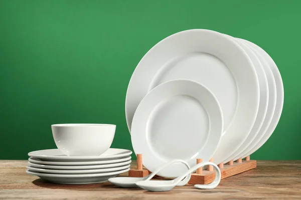 緑の背景に木製のテーブルの上にきれいな食器のセット — ストック写真