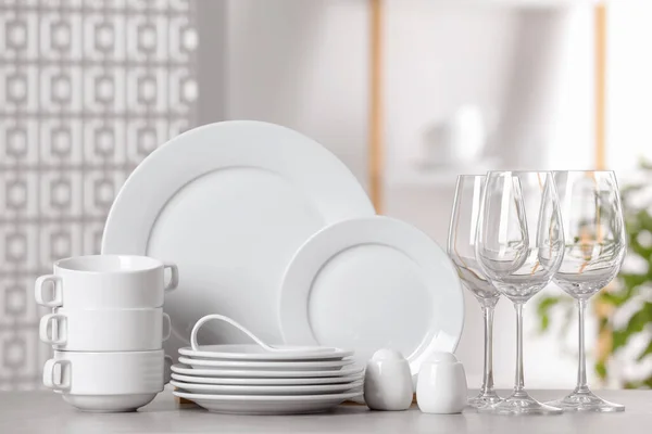 ライトグレーのテーブルの上にきれいな食器と眼鏡のセット — ストック写真