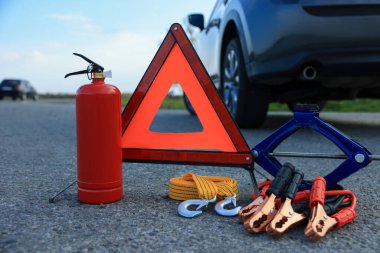 Emergency warning triangle and car safety equipment outdoors clipart